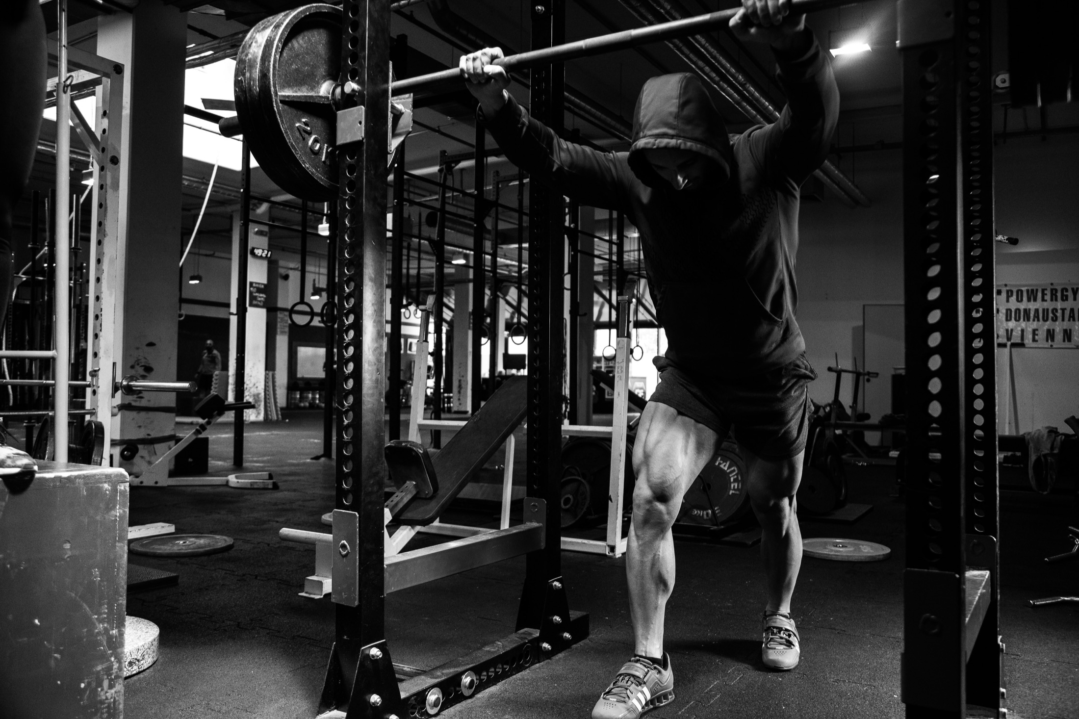Athlete training beneath a loaded barbell in a gym